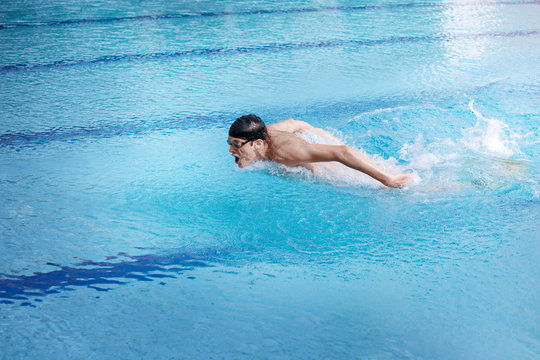 Swimmer in cap and goggles   performing the butterfly stroke