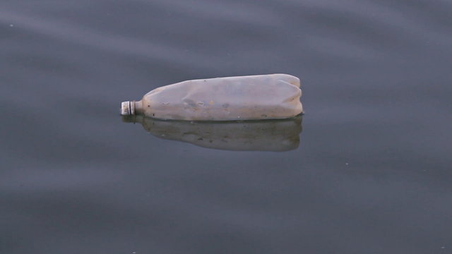 Plastic bottle floating and polluting at river