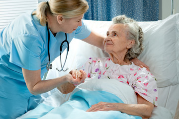 Nurse cares for a elderly woman lying in bed