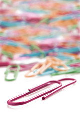 Colorful paper clips on a white background with space for text