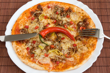 tasty chili pizza with fork and knife