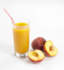 Glass with fresh peach juice near the slice peaches
