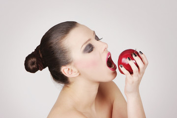 studio portrait of beautiful woman with red apple