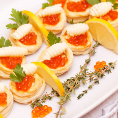 Canapes with red caviar and lemon