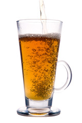 Pouring tea to glass with bubbles