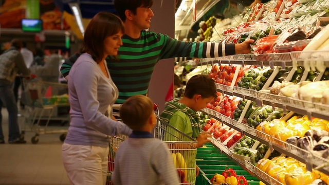 A family of four choosing vegetable in the supermarket