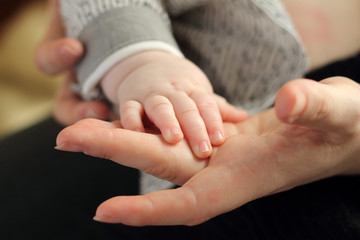A child hand in mom's hand