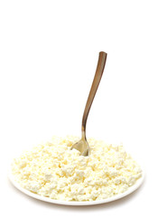 Heap of cottage cheese and spoon in white plate