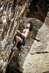Rock climber clinging to a cliff.