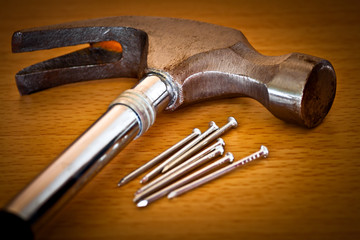 Hammer and nails on a wood background
