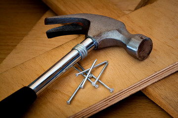Hammer and nails on a wood background