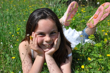 Fillette heureuse allongée dans les fleurs au printemps
