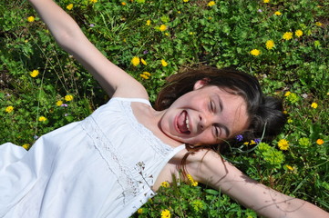 Fillette heureuse allongée dans les fleurs printemps