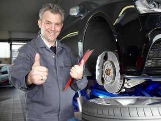 Master mechanic in a garage shows ok