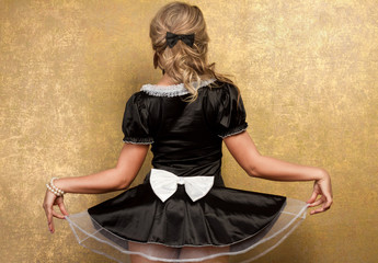 sexy blonde woman in seductive black dress on golden background