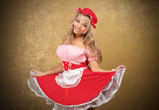 sexy blonde woman in red vintage dress on golden background