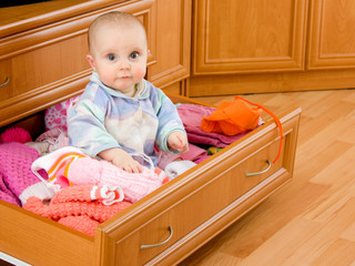 Baby was sitting in the closet.
