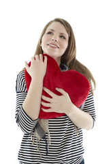 Woman cuddling with a heart pillow