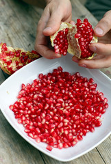 Male hands peeling pomegranate fruit
