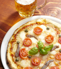 pizza con bicchiere di birra su tavolo di legno