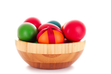 Easter eggs in wooden bowl isolated on white