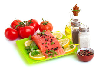 Red fish with pepper and green leaves isolated on white
