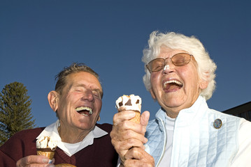 Elderly couple laughing at ice cream accident