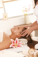 Obraz na płótnie Canvas Young woman enjoying facial massage