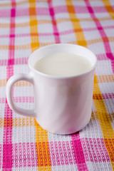 Mug of milk on a checkered tablecloth