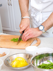 Chef cutting the beans on a wooden board