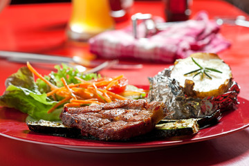gegrilltes Schweinesteak auf einer Platte im Freien