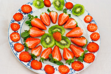 Fresh strawberries and kiwi fruit sliced  on a white
