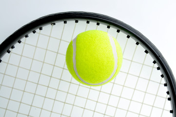 A tennis ball is on the racket and isolated on white background.