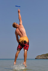 sportsman in water playing wit flying saucer