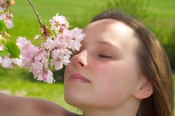 Frau riecht an Kirschbaumblüten