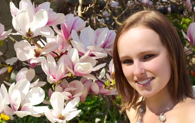 Frau steht vor einem Magnolienbaum