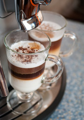 Two glasses fileed with capuccino in cofee machine
