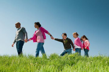 Family walking outdoors holding hands