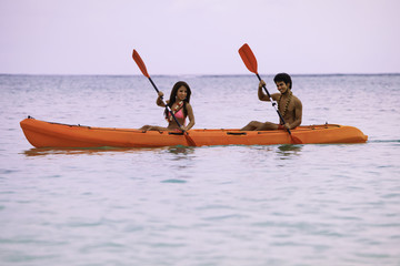 young asian couple in their kayak in hawaii