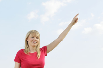 junge frau zeigt in den himmel