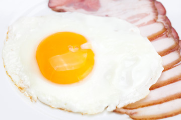 bacon and fried eggs on a plate isolated on white