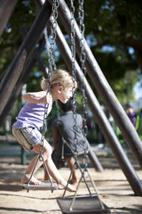 child balancing on swing, urban playground