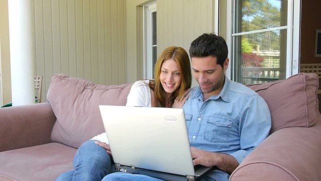 Couple websurfing on internet with laptop computer