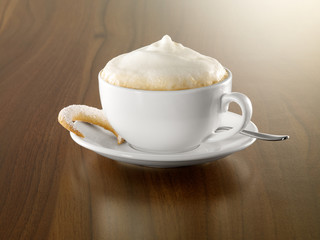 Cappuccino mit Gebäck und Löffel