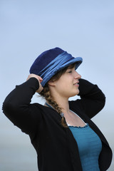 profile outdoors portrait of beautiful young woman with blue hat