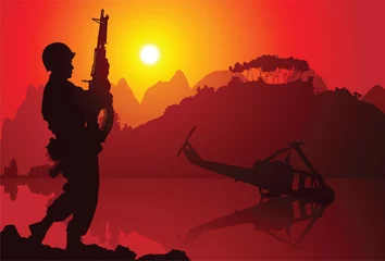 Foto op Plexiglas Soldaten Soldaat met neergestorte helikopter op de achtergrond