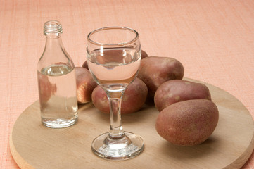 Kartoffelschnaps in einem Glas und eine kleine Flasche