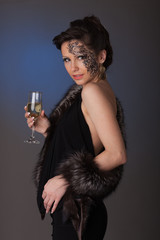 Young woman in furs with a glass of champagne.