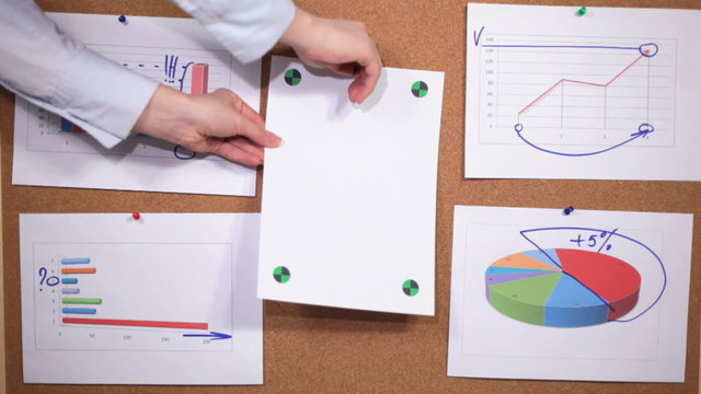 HD: a person leaves a sheet of paper on the pinboard