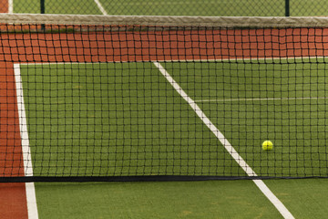 a tennis ball on a court behind a net